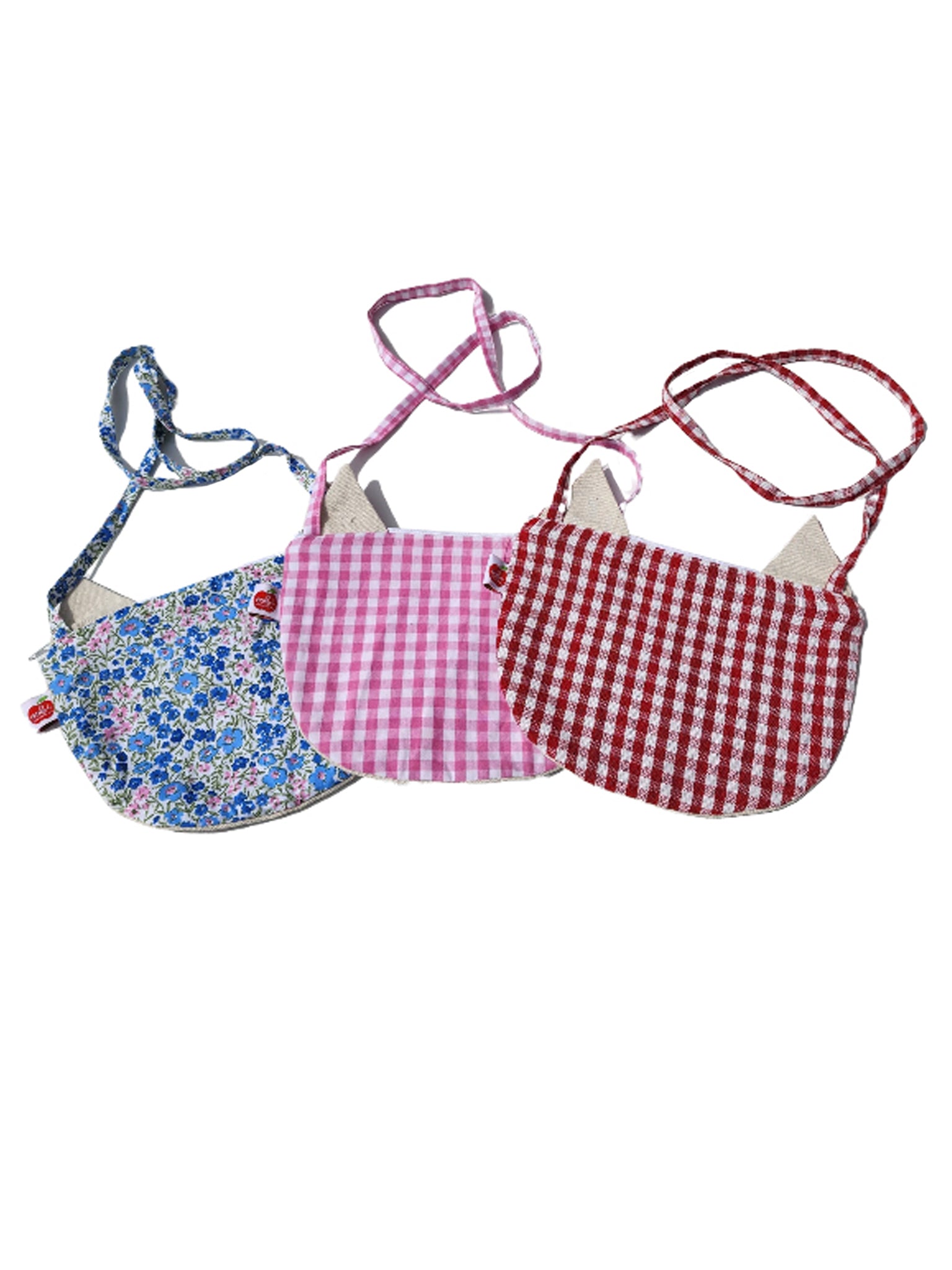 Three small Cat Bags from Oobi featuring different patterns: blue floral, pink gingham, and red gingham with cat-ear designs.