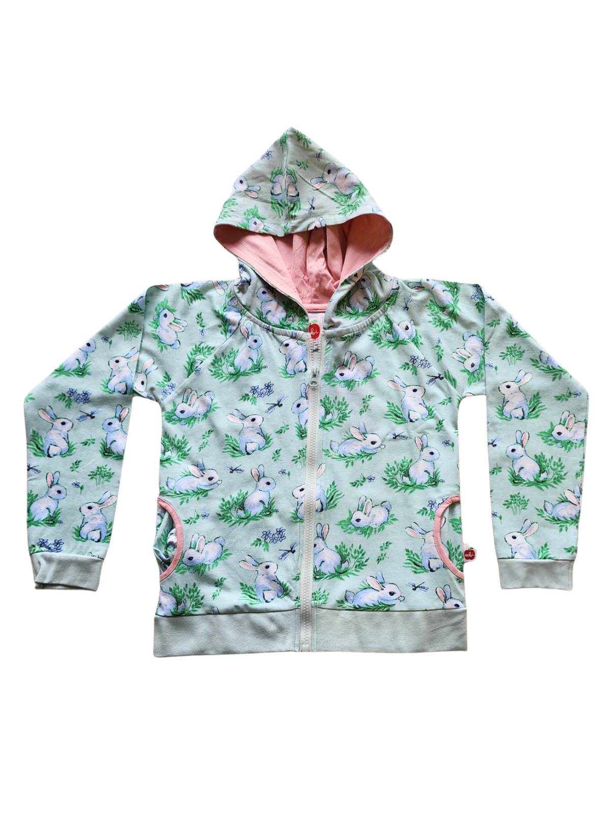 The Bun-Buns Blue Bun-Buns Zadie Jacket is a cozy children's hoodie featuring white bunnies and grass on a green exterior with a pink interior. Made of cotton, it has a zipper front and pockets, and pairs perfectly with the matching Soft Jersey Pants for a coordinated look.