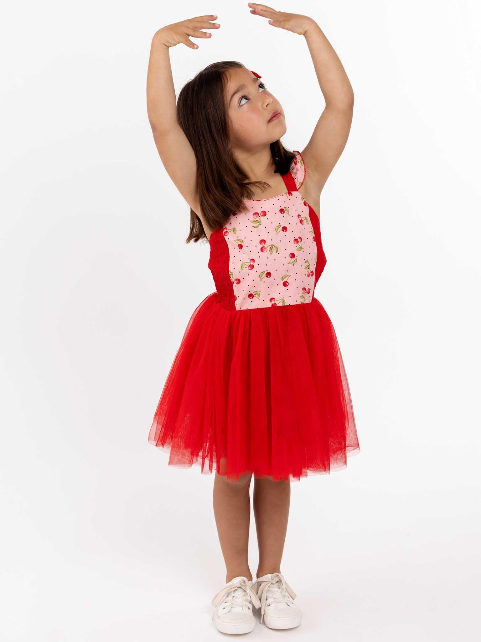 A little girl in a red tulle dress.