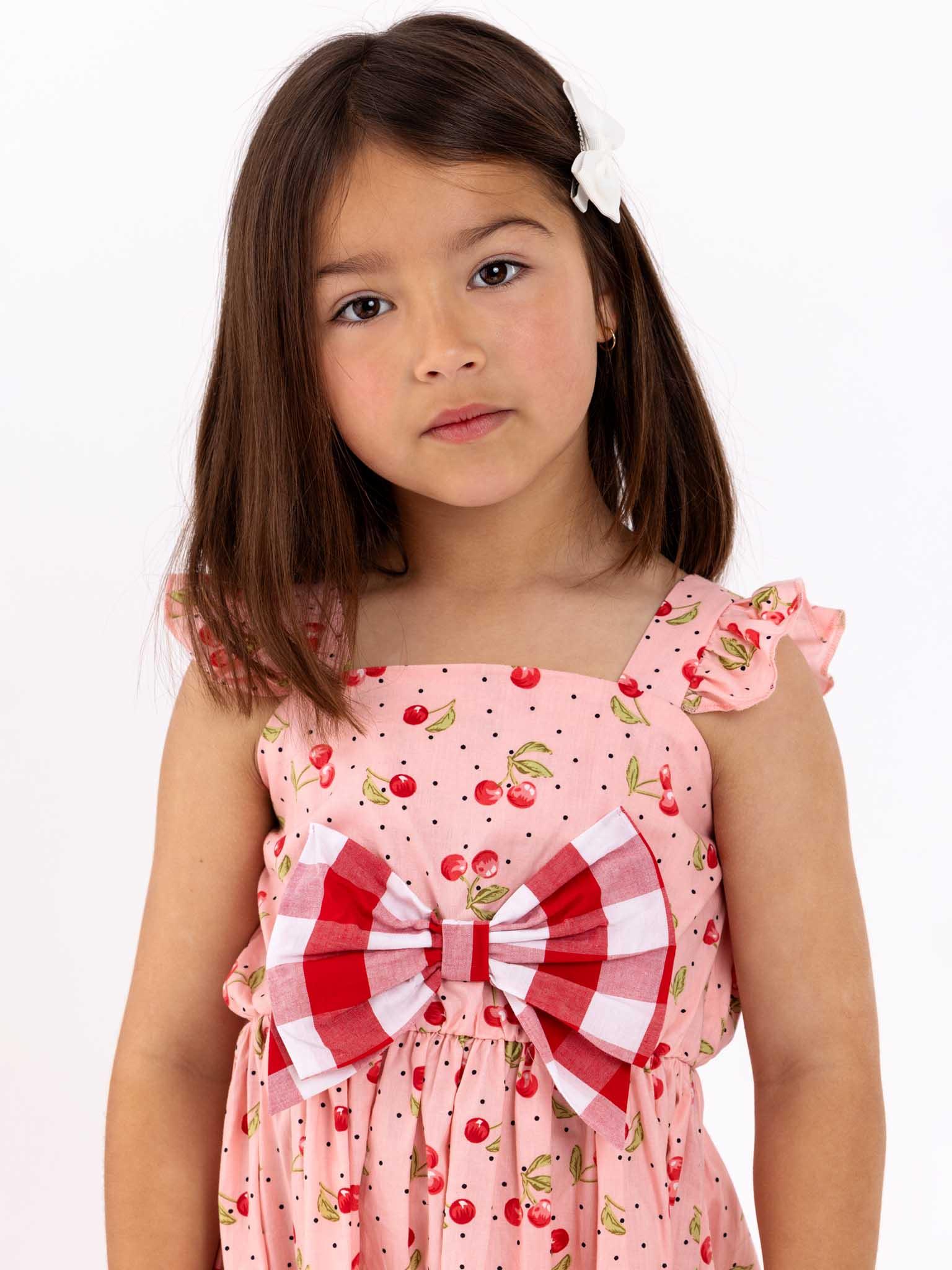 Retro Cherry's Cherry Ripe Mia Dress, worn by a little girl in a pink dress, exudes vintage styling reminiscent of 1950s style fun.