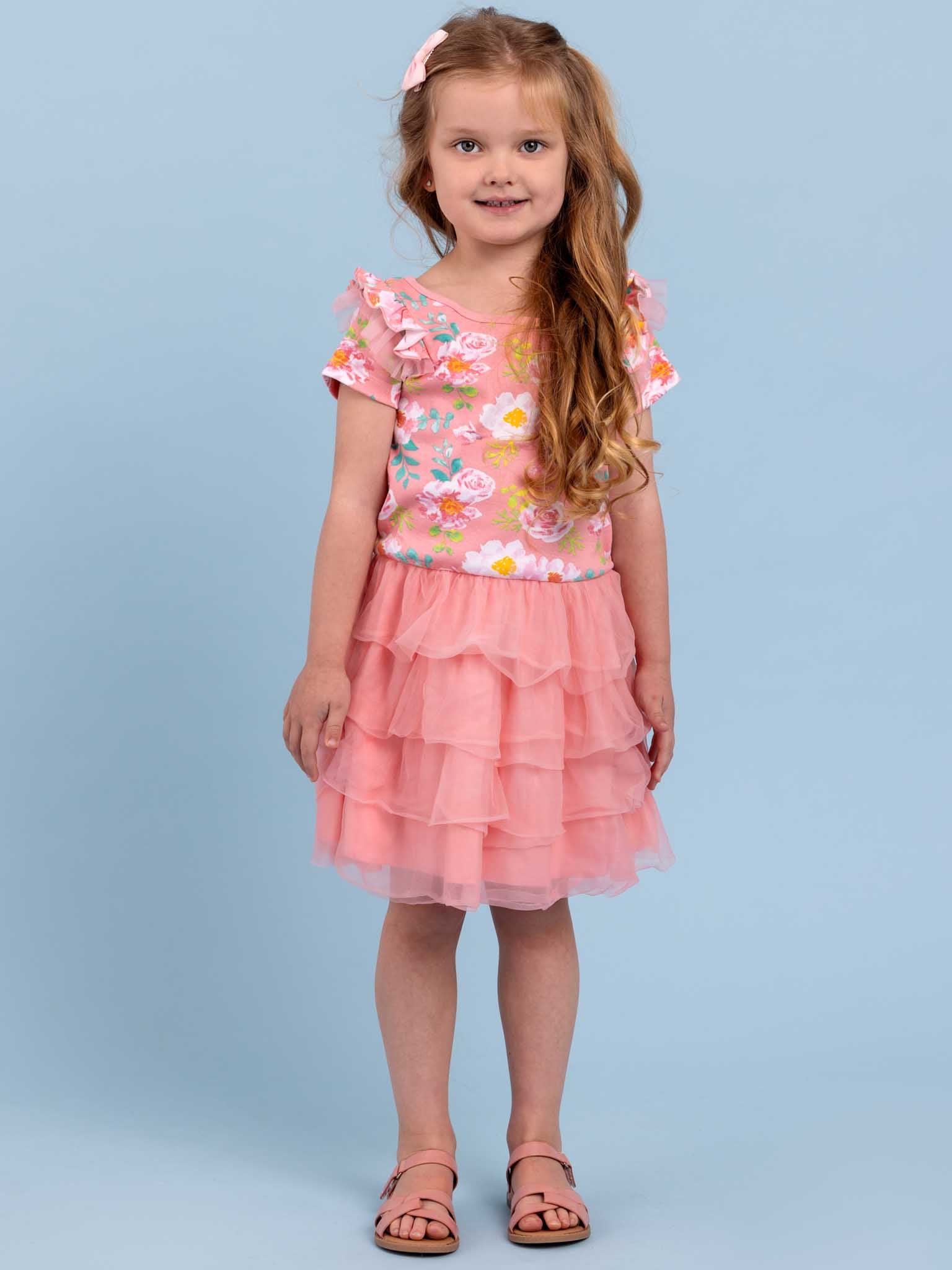 A little girl wearing a Lola Pink Watercolour Dress by Watercolour.