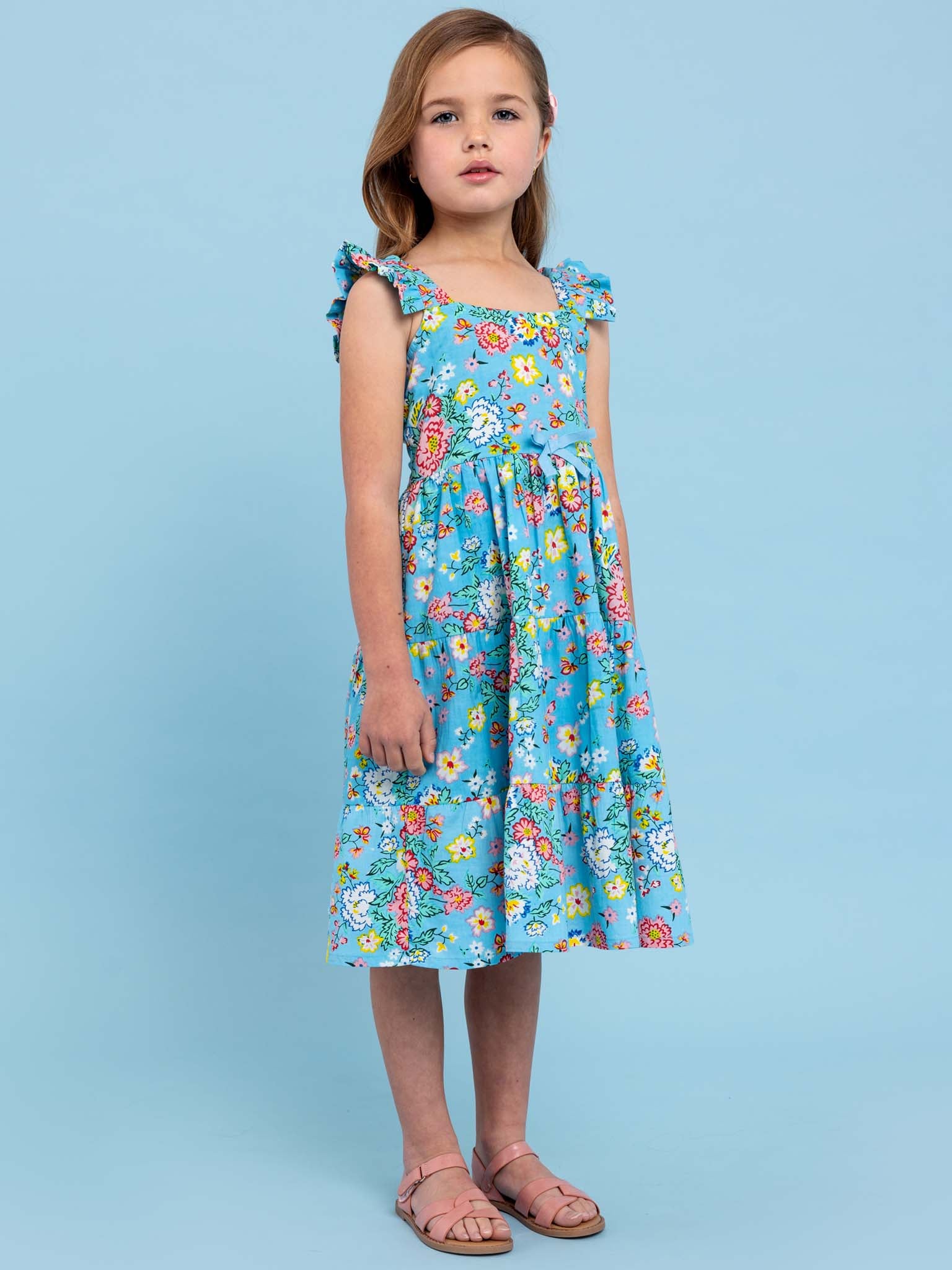 A girl in a Cornflower Meadow Midi-Maxi Dress by Cornflower standing on a blue background.