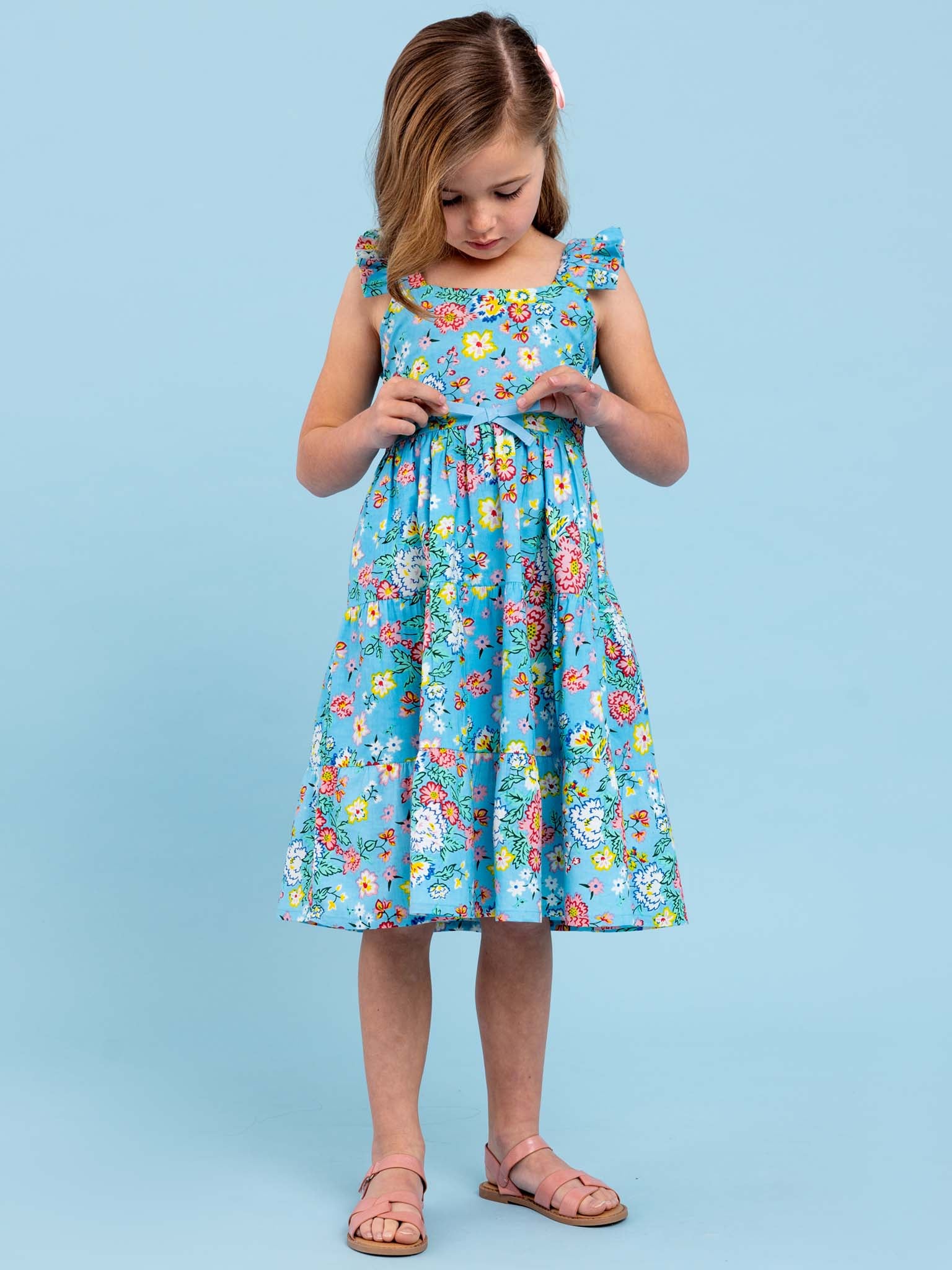 A little girl wearing a Cornflower Meadow Midi-Maxi Dress, the beloved print summer dress by Cornflower.