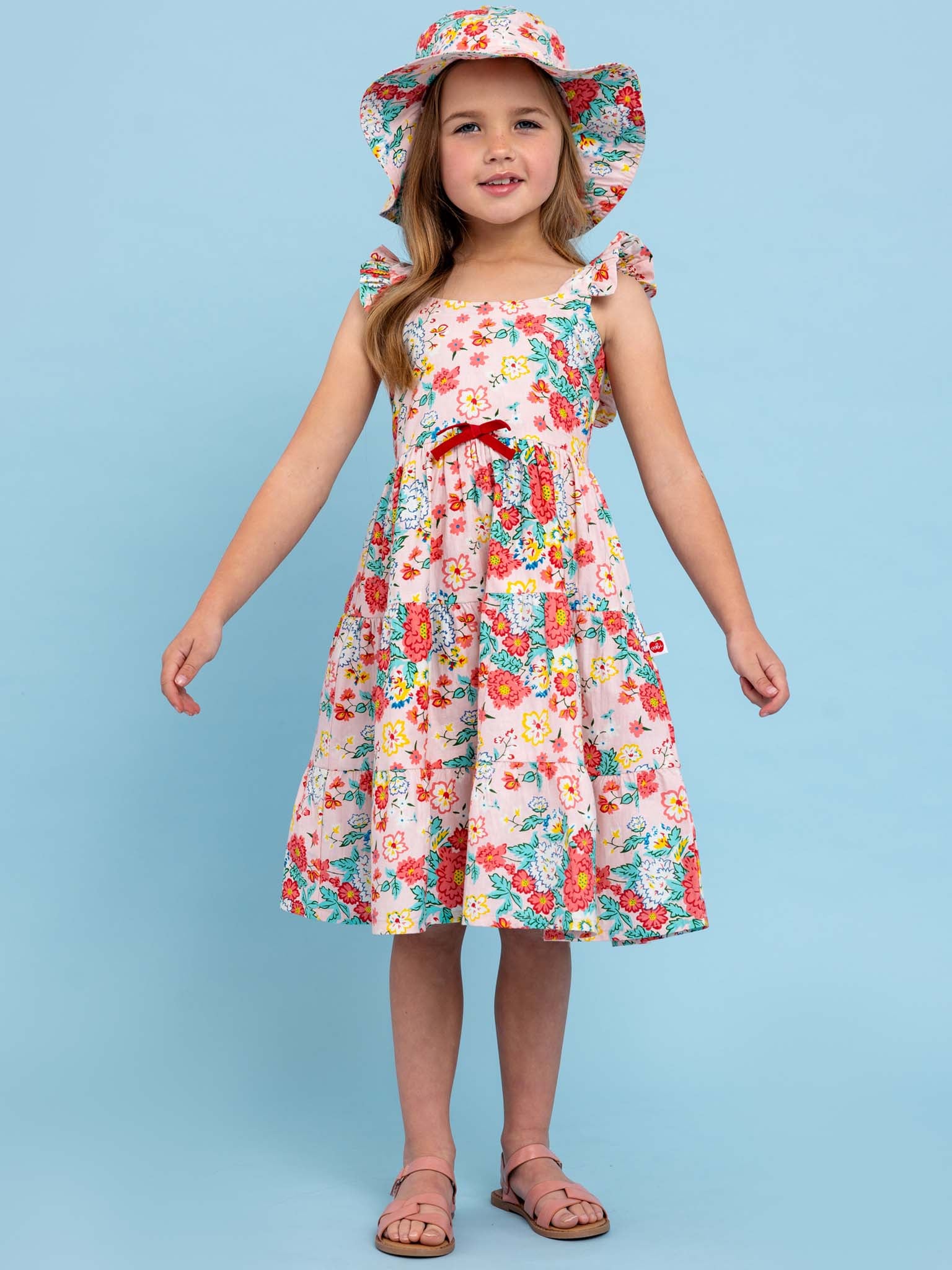 A little girl in a Wild Meadow Maxi Dress from Cornflower with flowers in bloom.