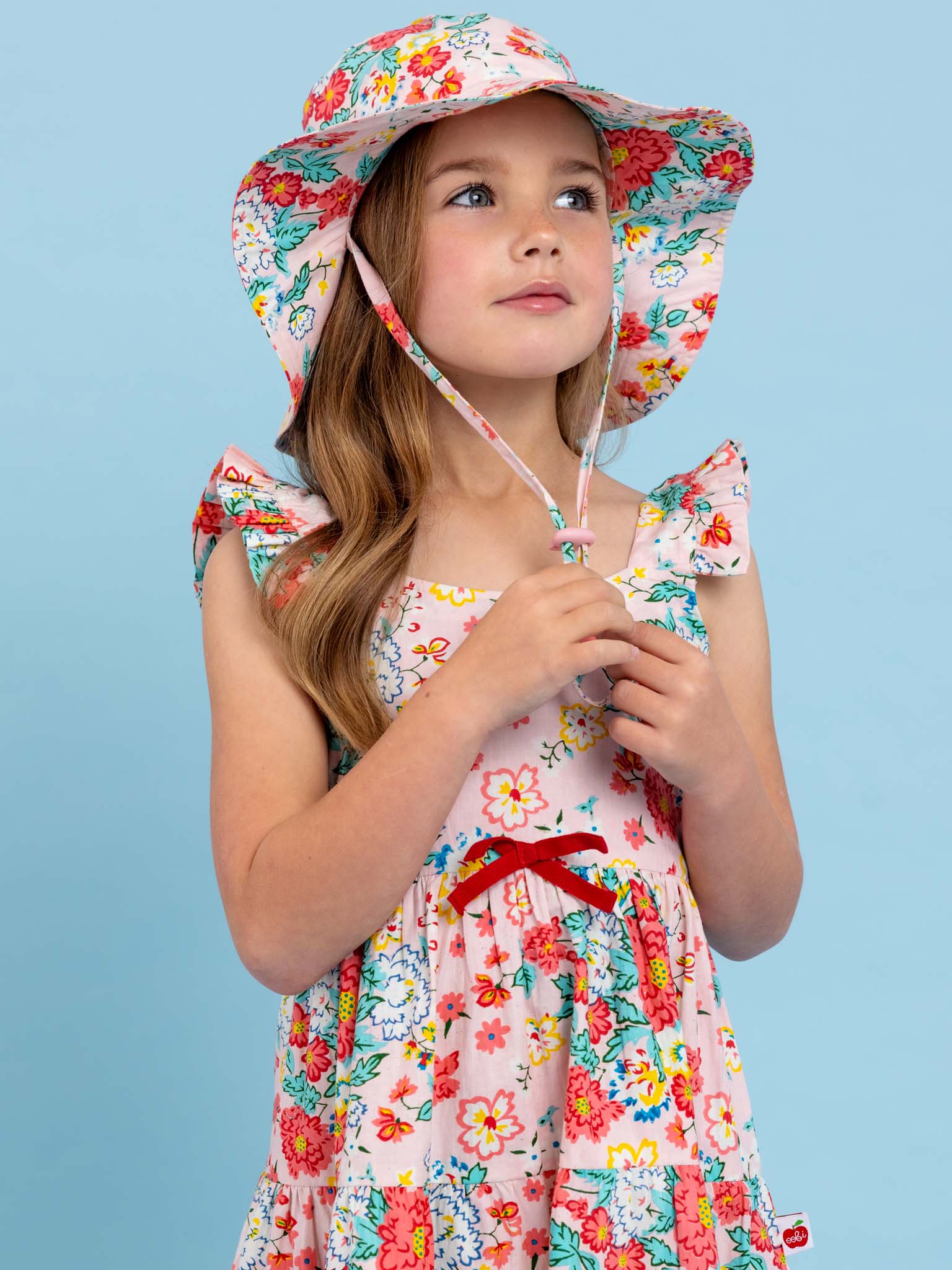 A little girl wearing a Cornflower Wild Meadow Maxi Dress in a wild meadow.