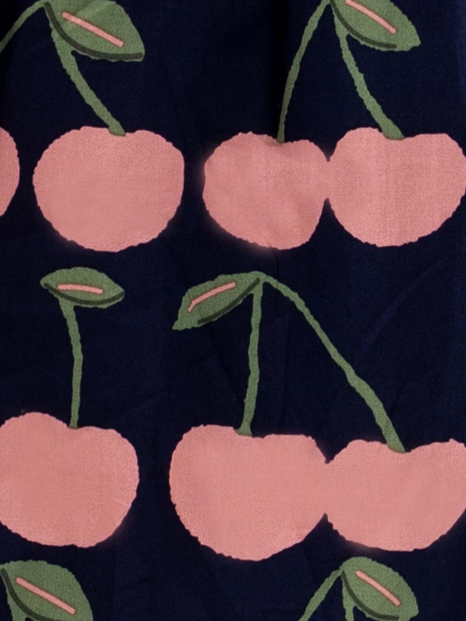 A close up of Navy Cherry Belle Tutu Dress cherries on a navy background, twirl-approved.