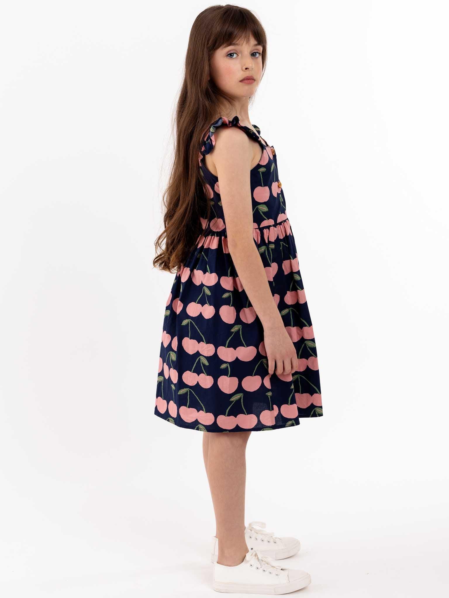 A Navy Cherry Calista Dress for girls with cherries on it.