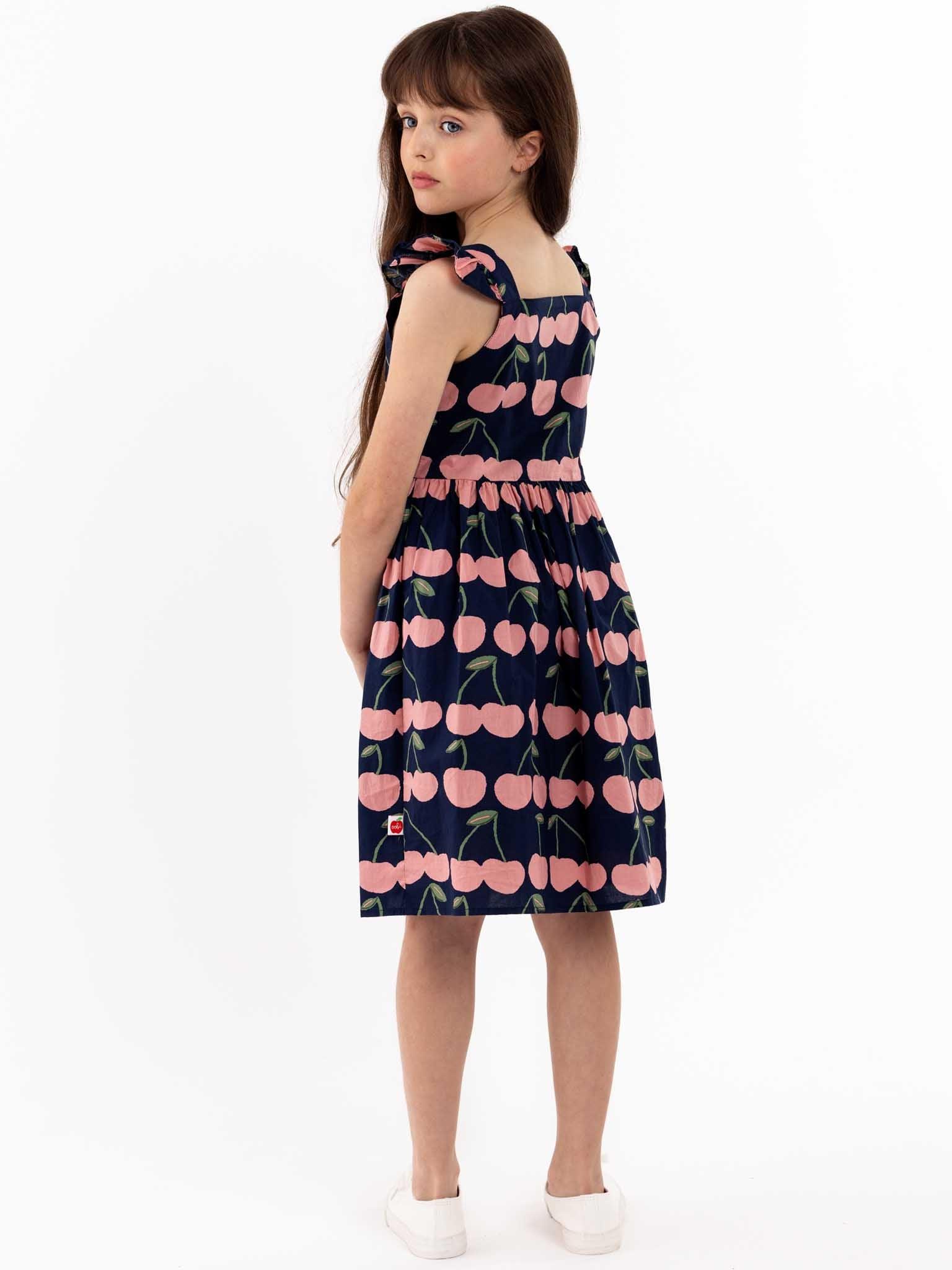 A young girl wearing a Navy Cherry Calista Dress.