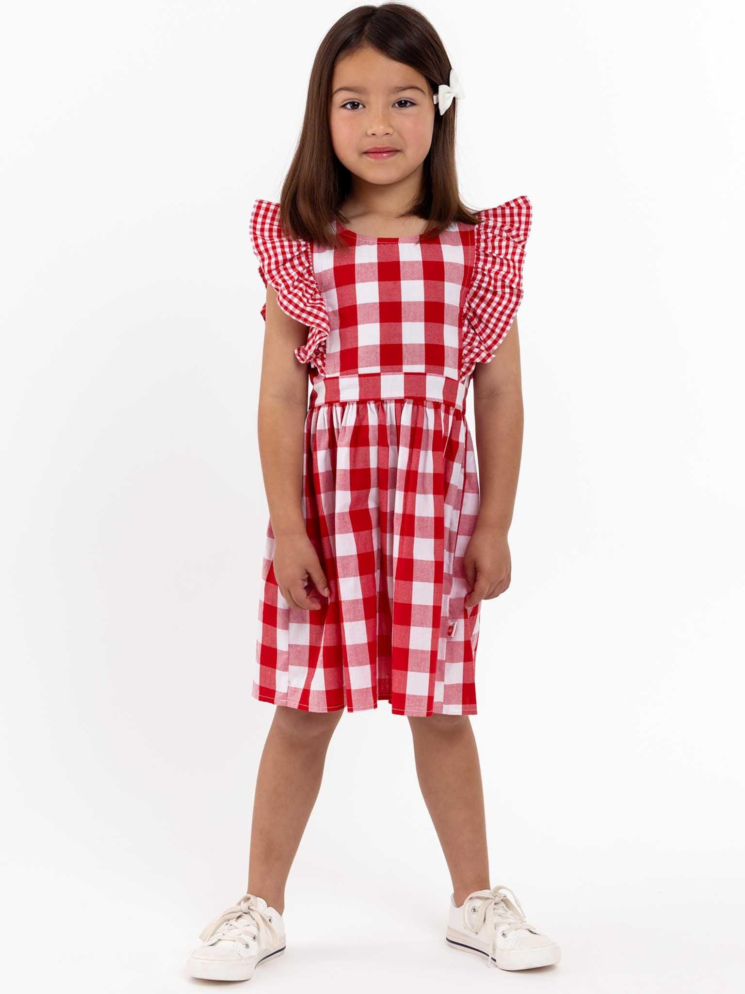 A little girl in a Red Check Jayne Dress from the brand Red Check.