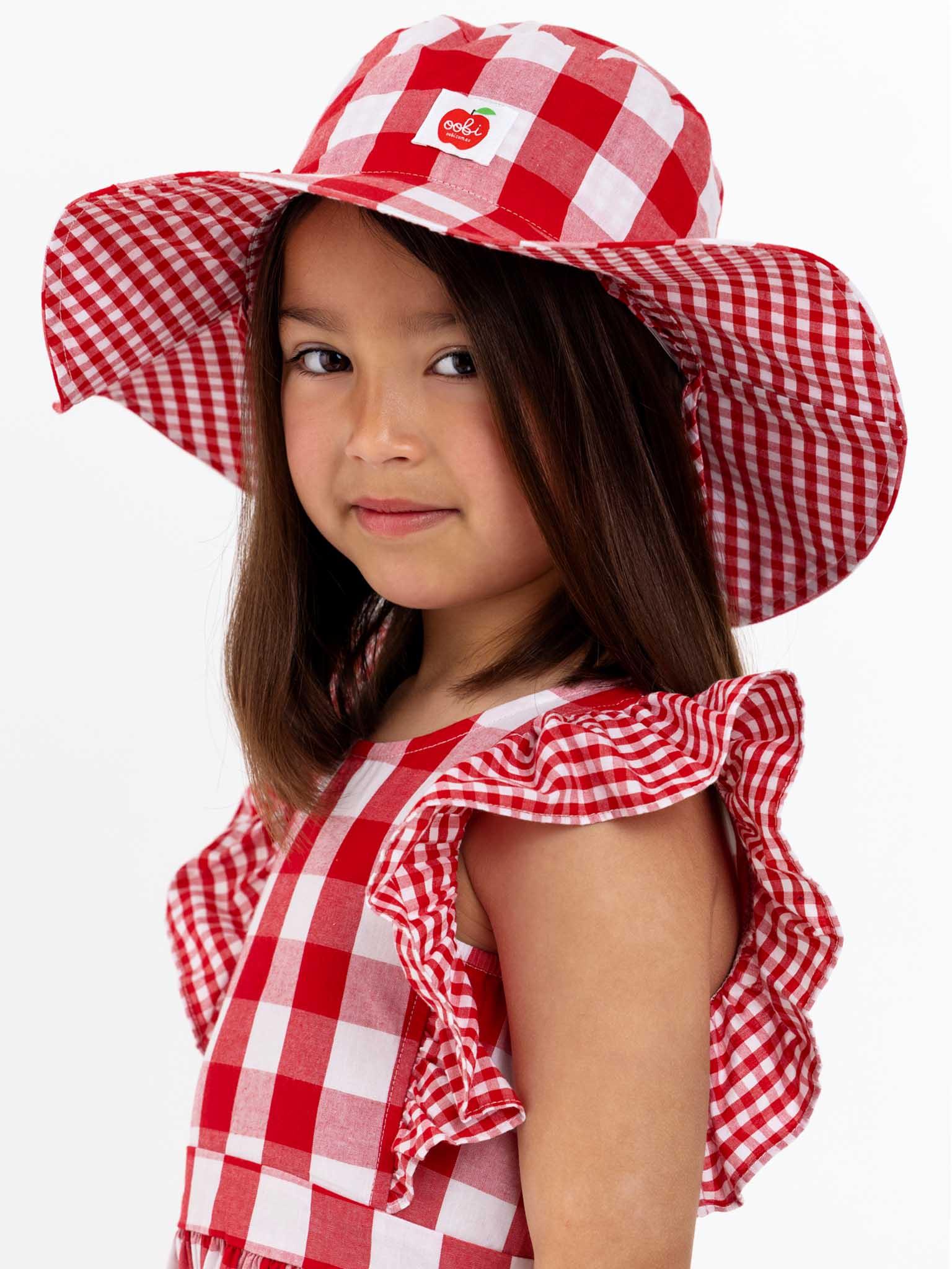 A little girl wearing a Red Check Jayne Dress by Red Check.