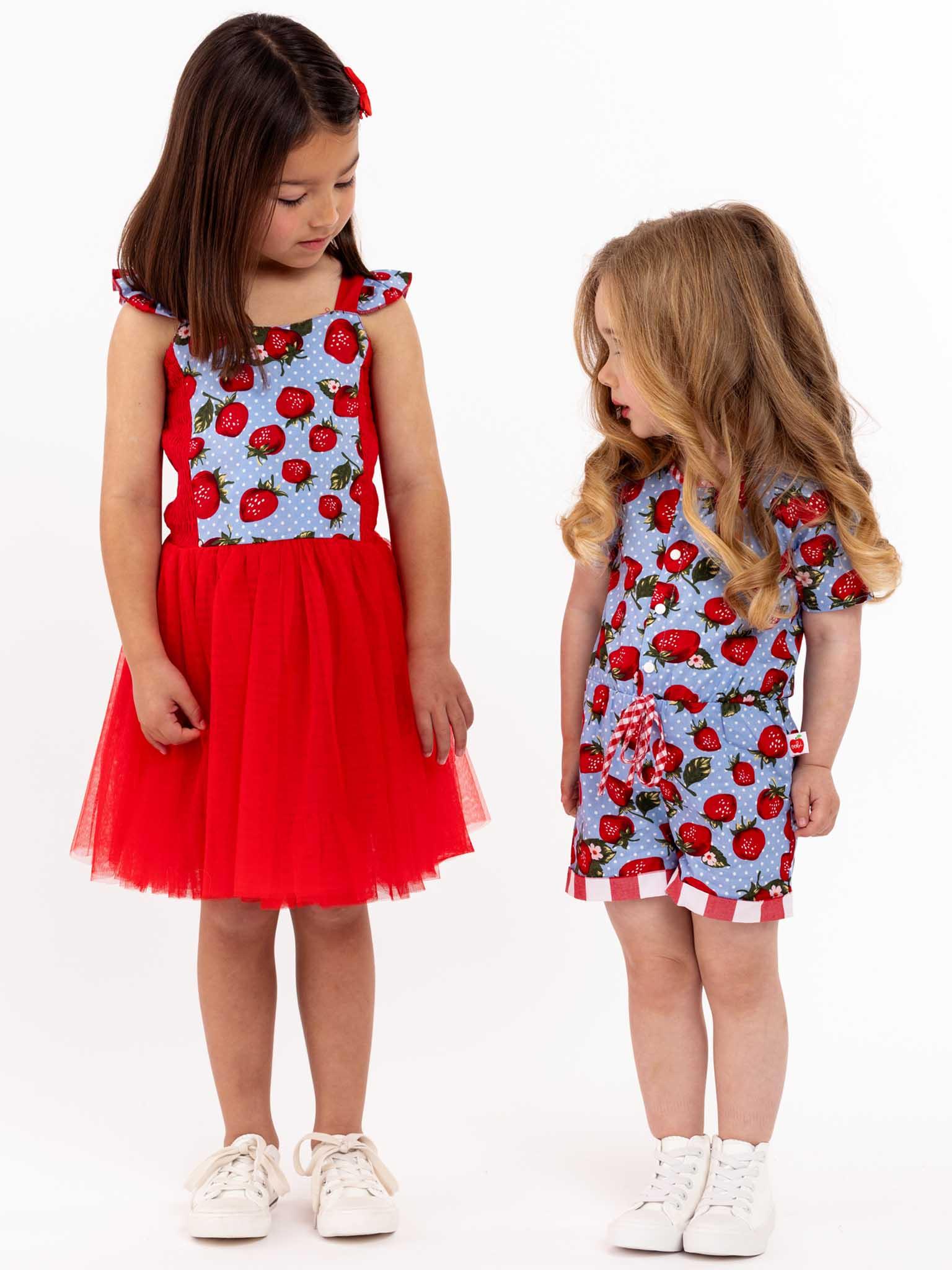 Two little girls wearing Strawberry Fields Belle Tutu Dresses stand next to each other with twirl approved cotton bodice.