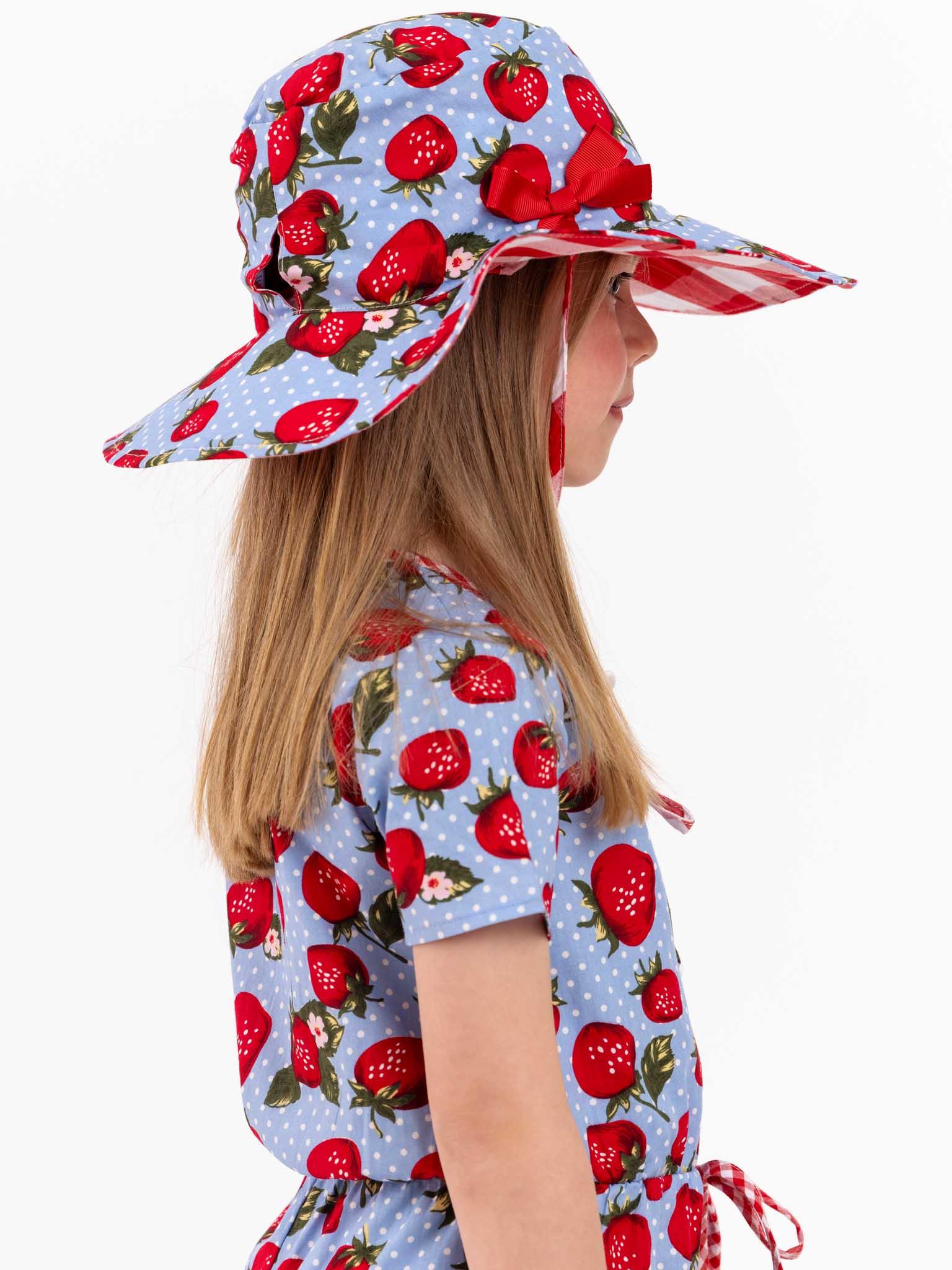 A little girl wearing a Strawberry Fields Chloe Hat.