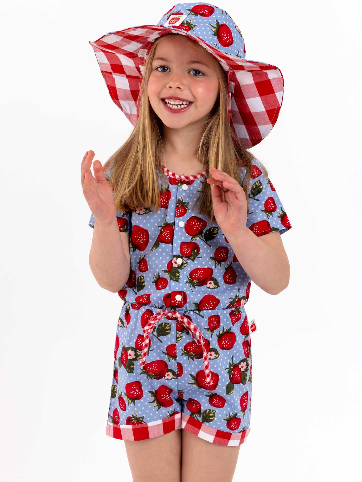 A little girl wearing a Strawberry Fields Maisy Playsuit