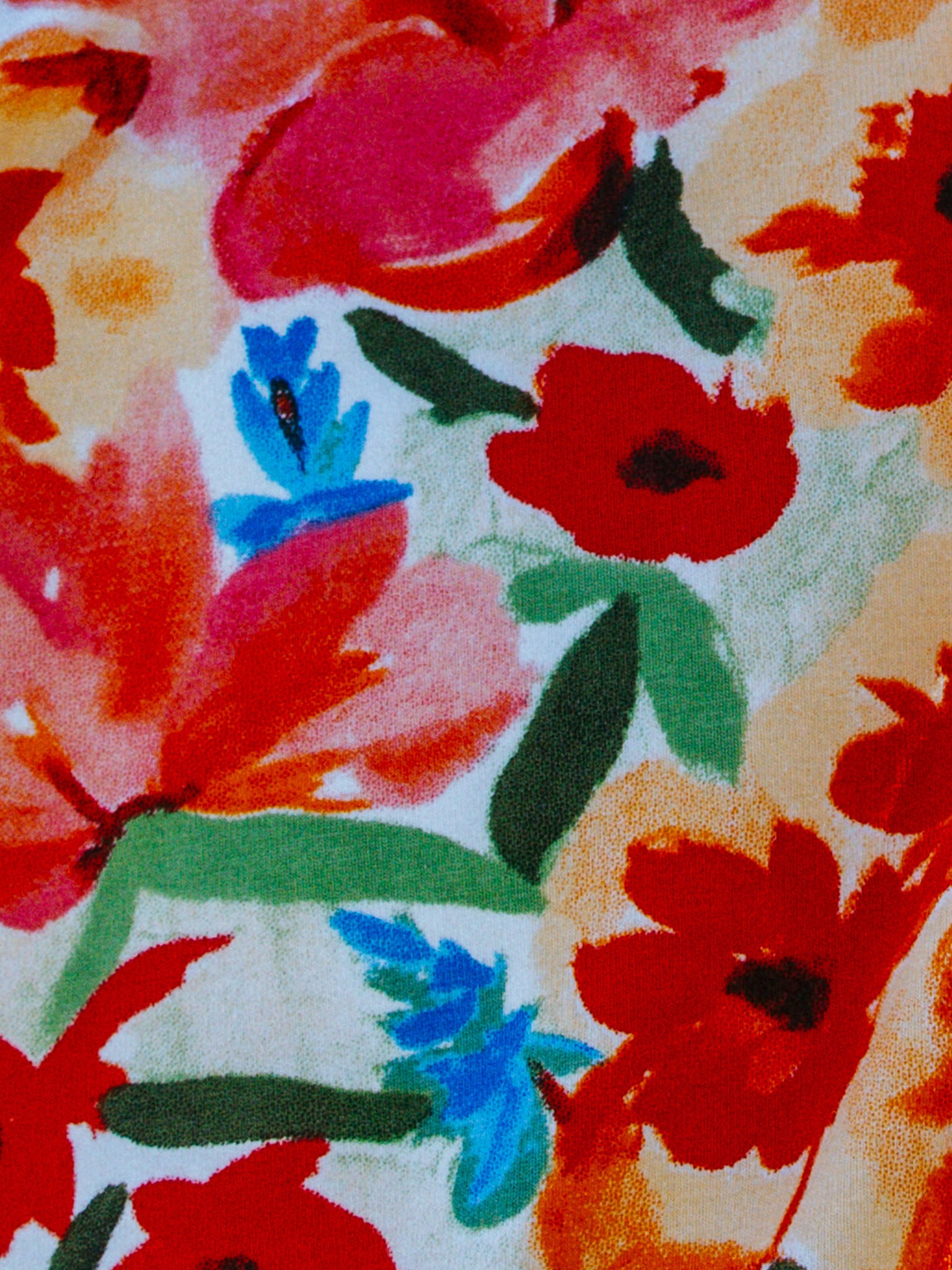 The Wild Roses Ariel Dress features a vivid print of red, orange, and blue flowers against a light background, accented by green leaves—a perfect addition to our Girls Dresses collection.